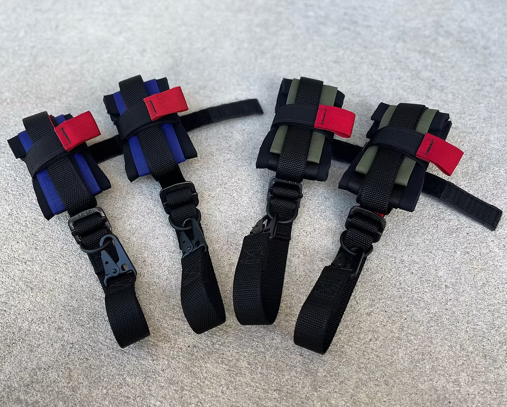 Set of four XDcuff (REF115C+) black straps with red and blue accents on a gray surface