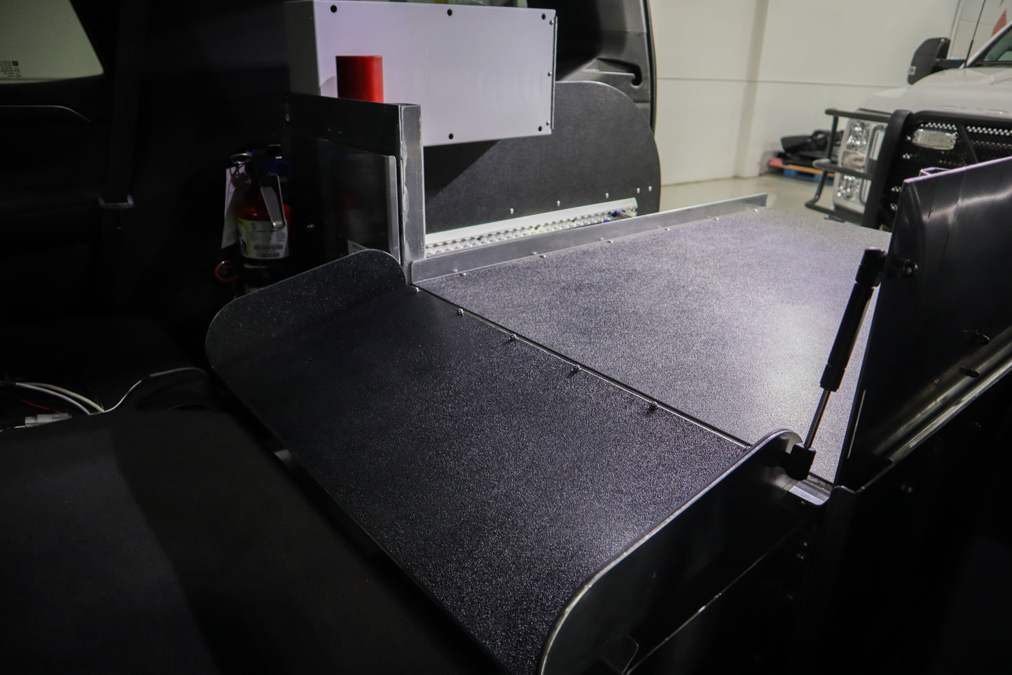 Foldable insert in Chevrolet Tahoe rear cargo storage for emergency response use.