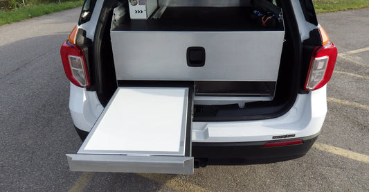 Rear storage system for a Ford Explorer, featuring a large drawer, desk, and open compartment for organized and accessible equipment storage.