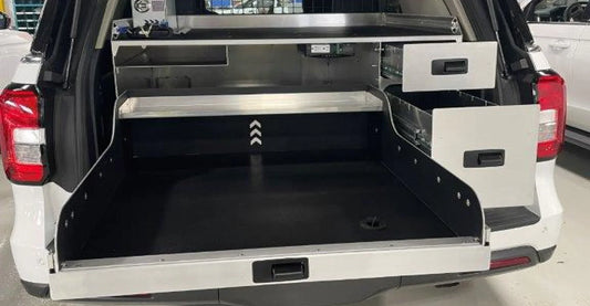 Rear cargo storage system with a left tray and two small drawers on the right, designed for a Ford Expedition emergency response unit, offering organized and efficient equipment storage.