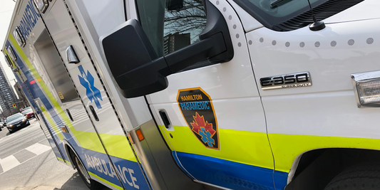 Hamilton Paramedic ambulance with EMS decals on city street, Rowland Emergency custom vehicle