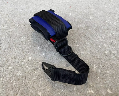 Black and blue XDcuff REF115C strap with a buckle on a gray surface