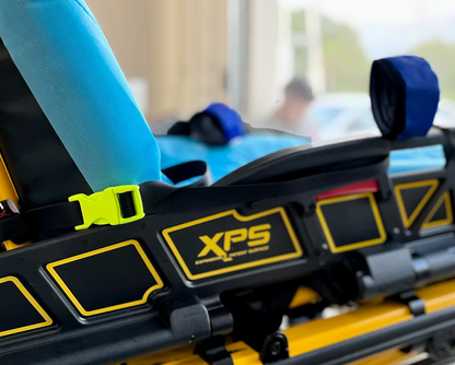Close-up of a yellow and black XPS side rail on a Power-PRO XT stretcher with an XDcuff REF105 strap and a blurred background