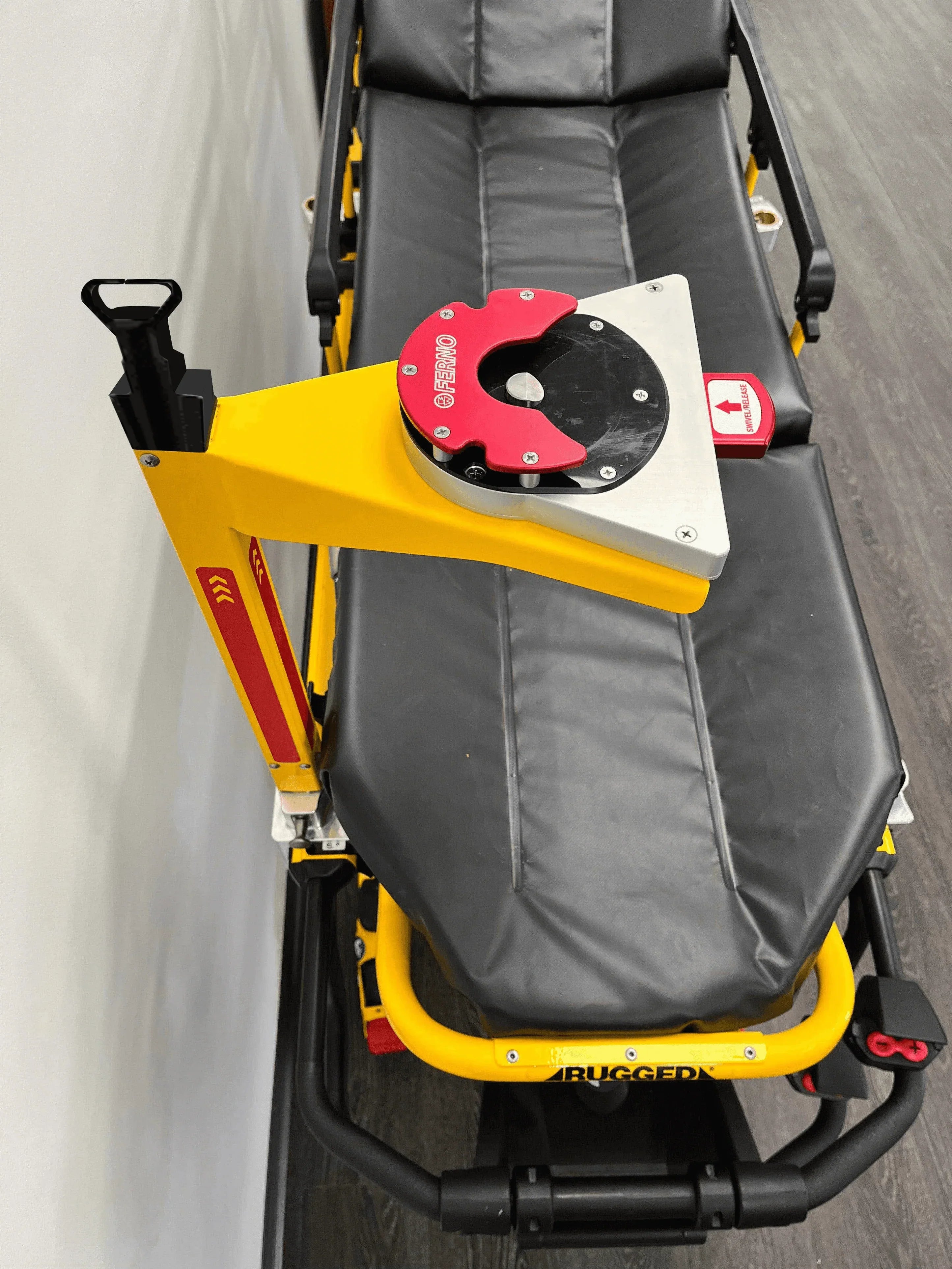 Yellow Ferno D360 stretcher pole with adapter IV receptacle attached to EMS cot